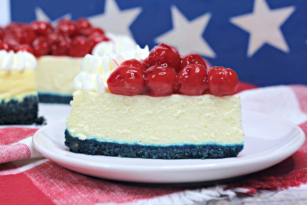 close up of a slice of patriotic cheesecake on a white plate