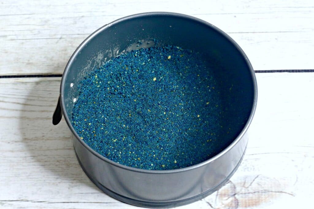 blue graham cracker crumbs in a springform pan