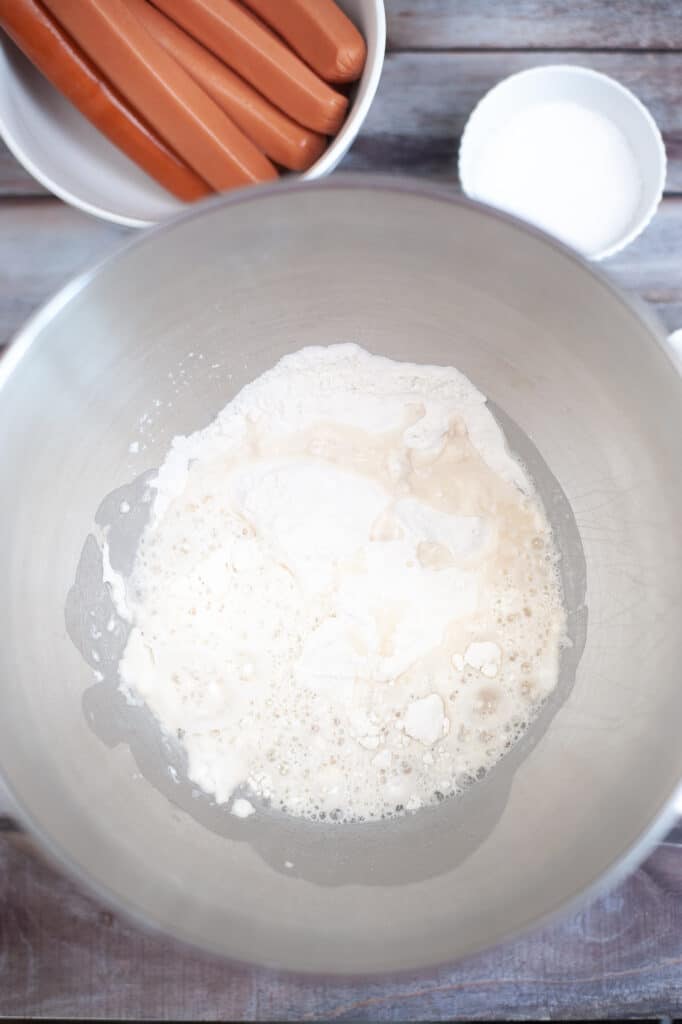 flour and yeast in a stainless steel mixing bowl
