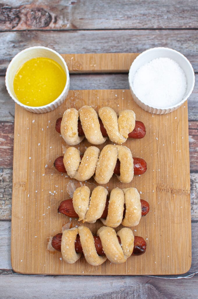 cooked air fryer pretzel dogs on wooden cutting board