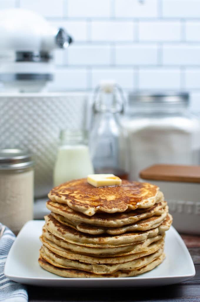 Stack of sourdough discard pancakes on a white plate
