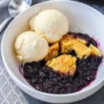 close up of a bowl filled with slow cooker blueberry cobbler