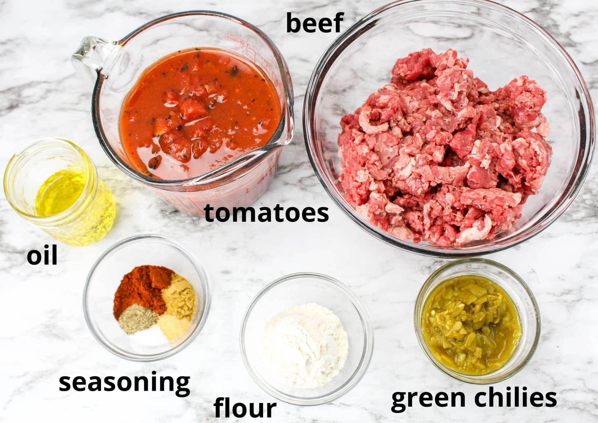 ingredients for carne picada on a marble backdrop labelled with text