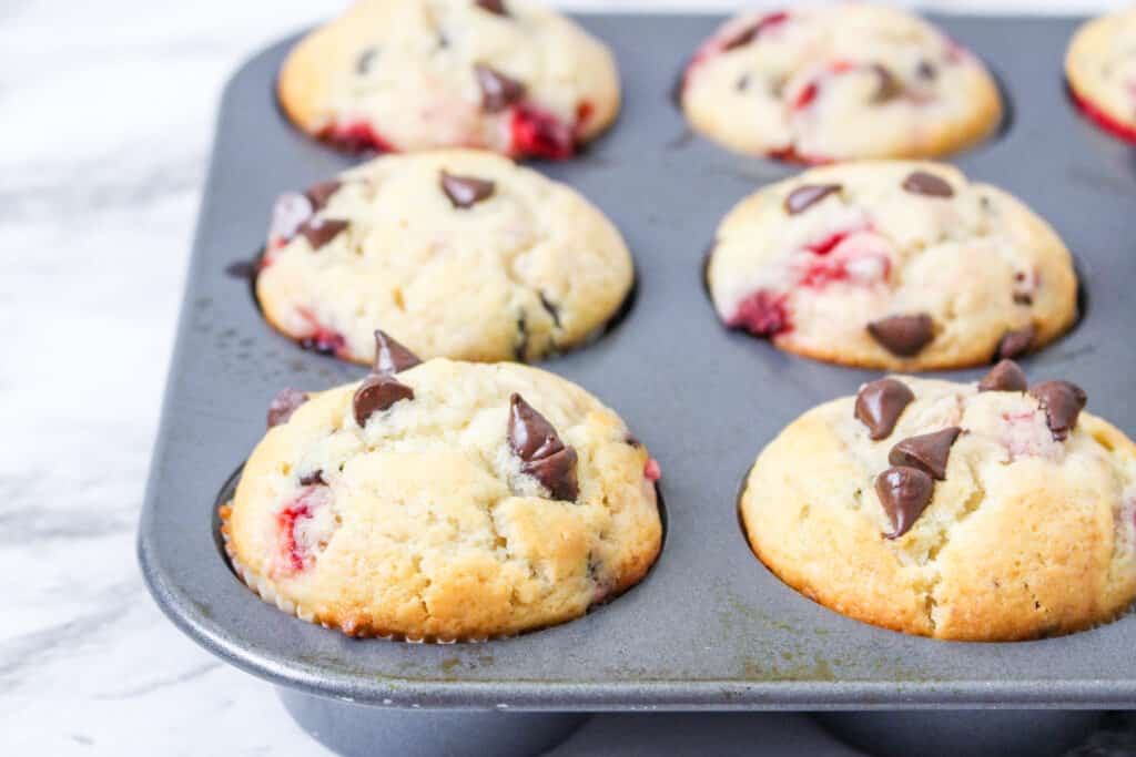 baked strawberry chocolate chip muffins in a muffin pan