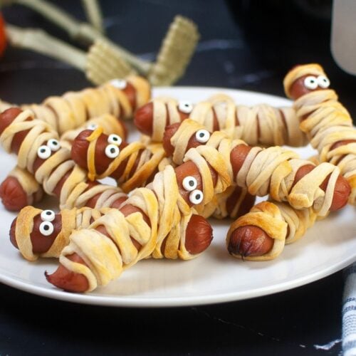 stack of air fryer mummy dogs on a white plate