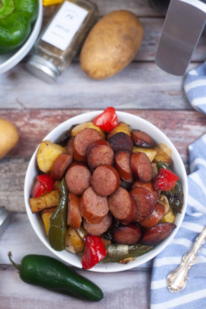 birds eye image of air fryer kielbasa and vegetables in a white bowl