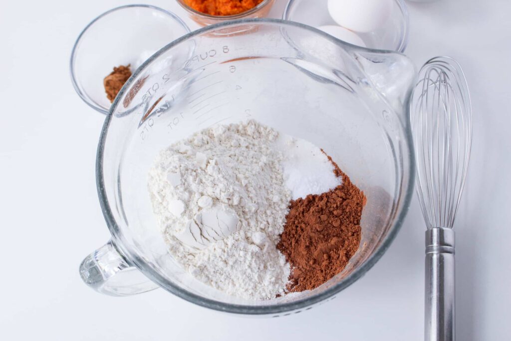flour, sugar, and cocoa powder in a glass mixing bowl