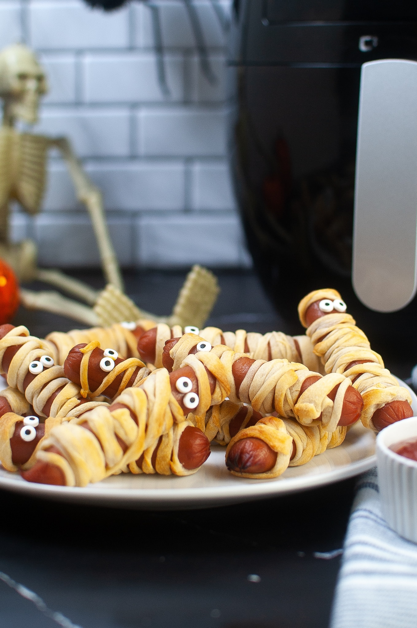stack of air fryer mummy dogs on a white plate