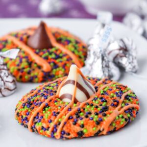 halloween sprinkle cookies on a white plate with hershey kisses