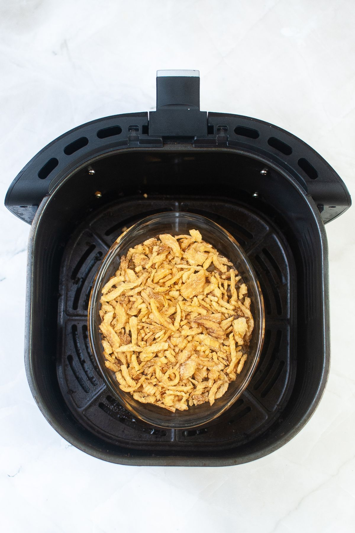glass dish filled with food inside the air fryer basket