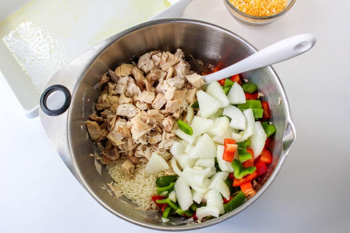 rice, chicken, onions, peppers and cream cheese in a stainless steel mixing bowl