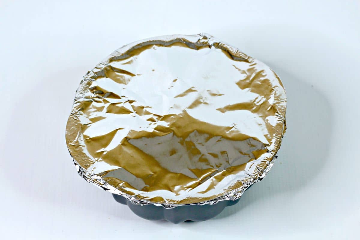 cake pan covered with foil on a white backdrop