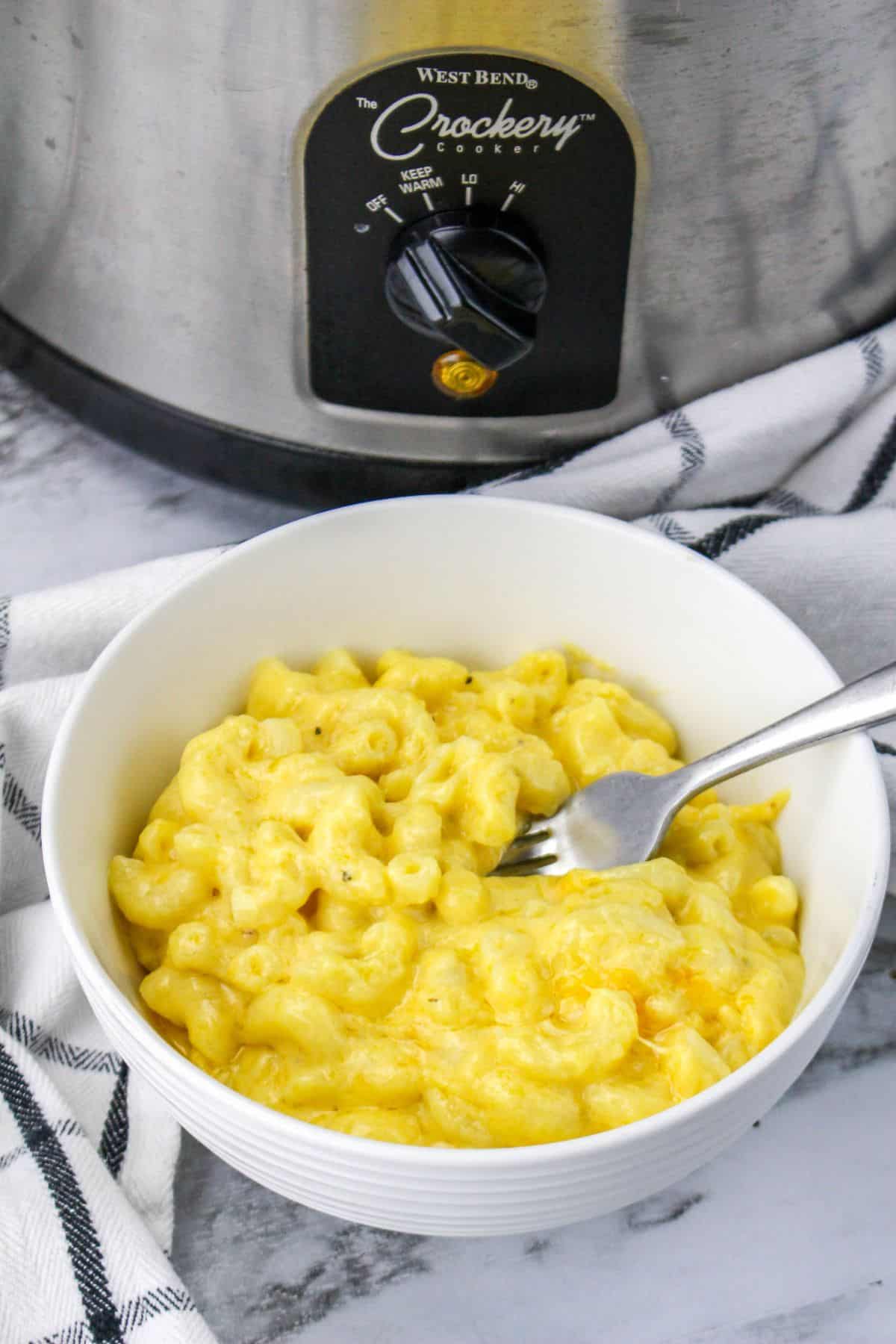 white bowl filled with slow cooker mac and cheese on a marble counter