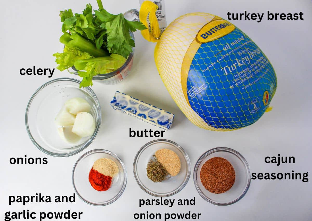 celery sticks, turkey breast, onions, butter, paprika, garlic powder, parsley, onion powder, and cajun seasoning on a white backdrop