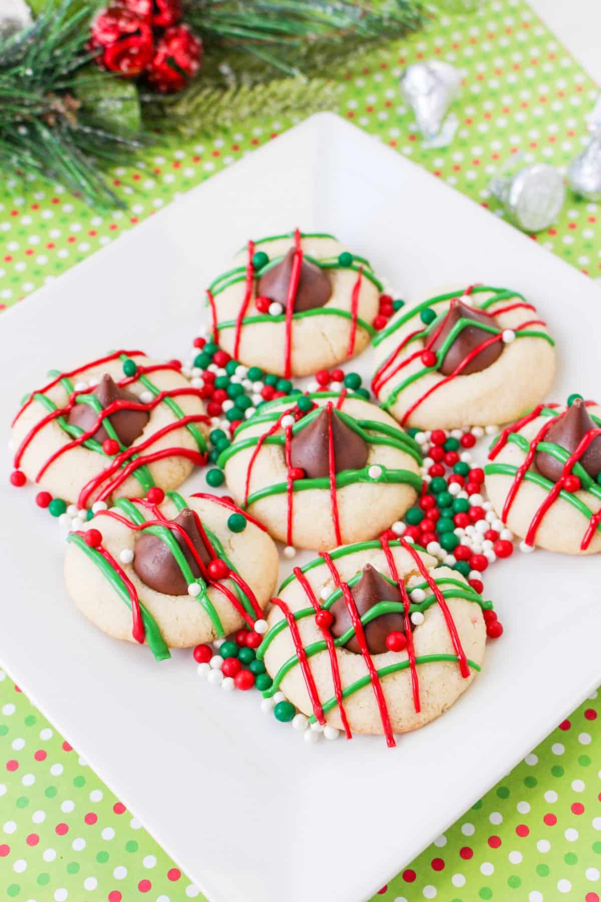 christmas blossom cookies on a white square plate with round red, white and green sprinkles