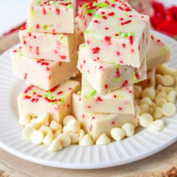 christmas cookie fudge staked on a white plate with white chocolate chips