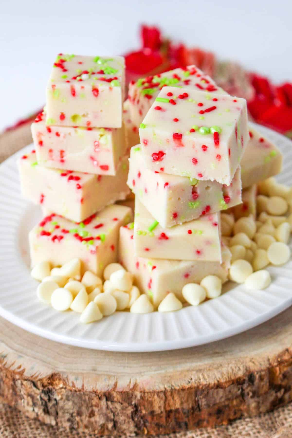 christmas cookie fudge staked on a white plate with white chocolate chips