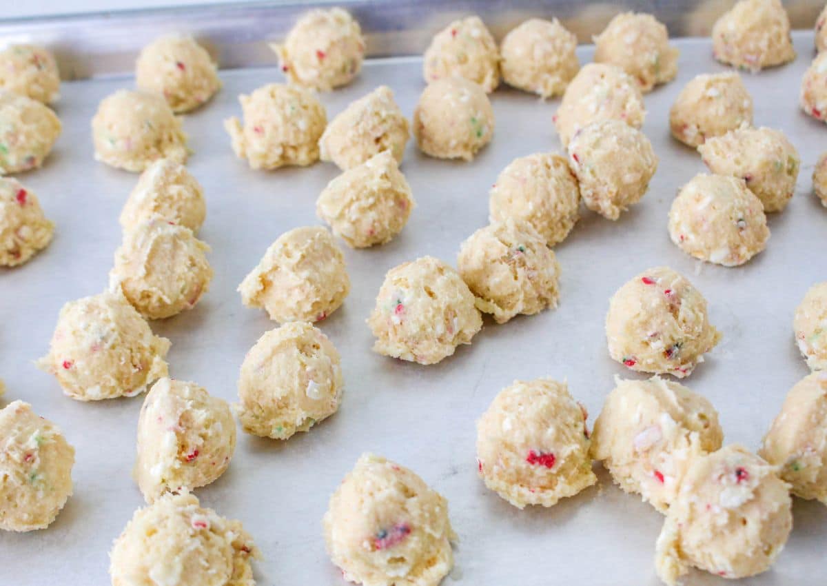 cake balls laid out on a parchment lined baking sheet ready to be dipped in white chocolate