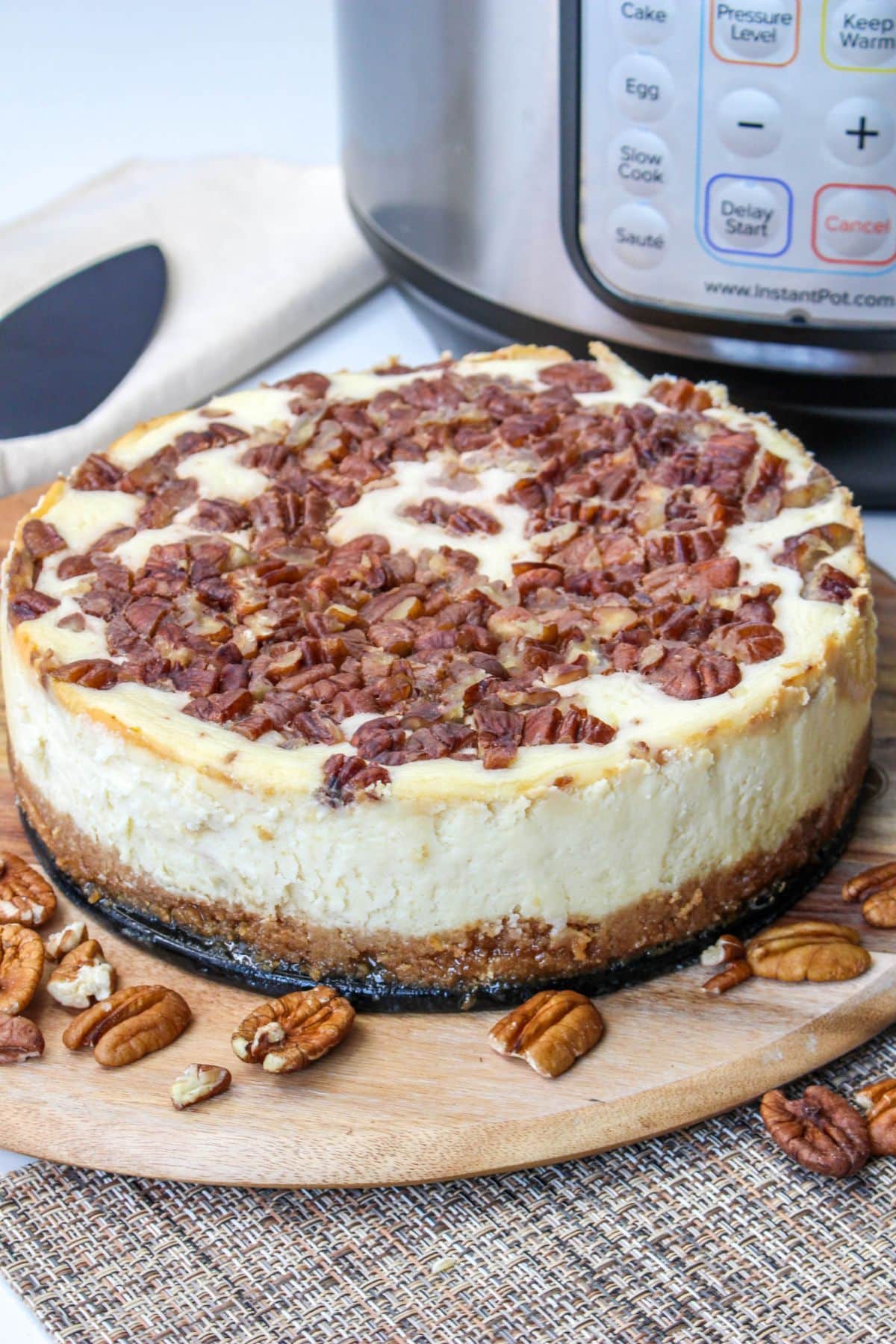 whole pecan pie cheesecake on a wooden cutting board