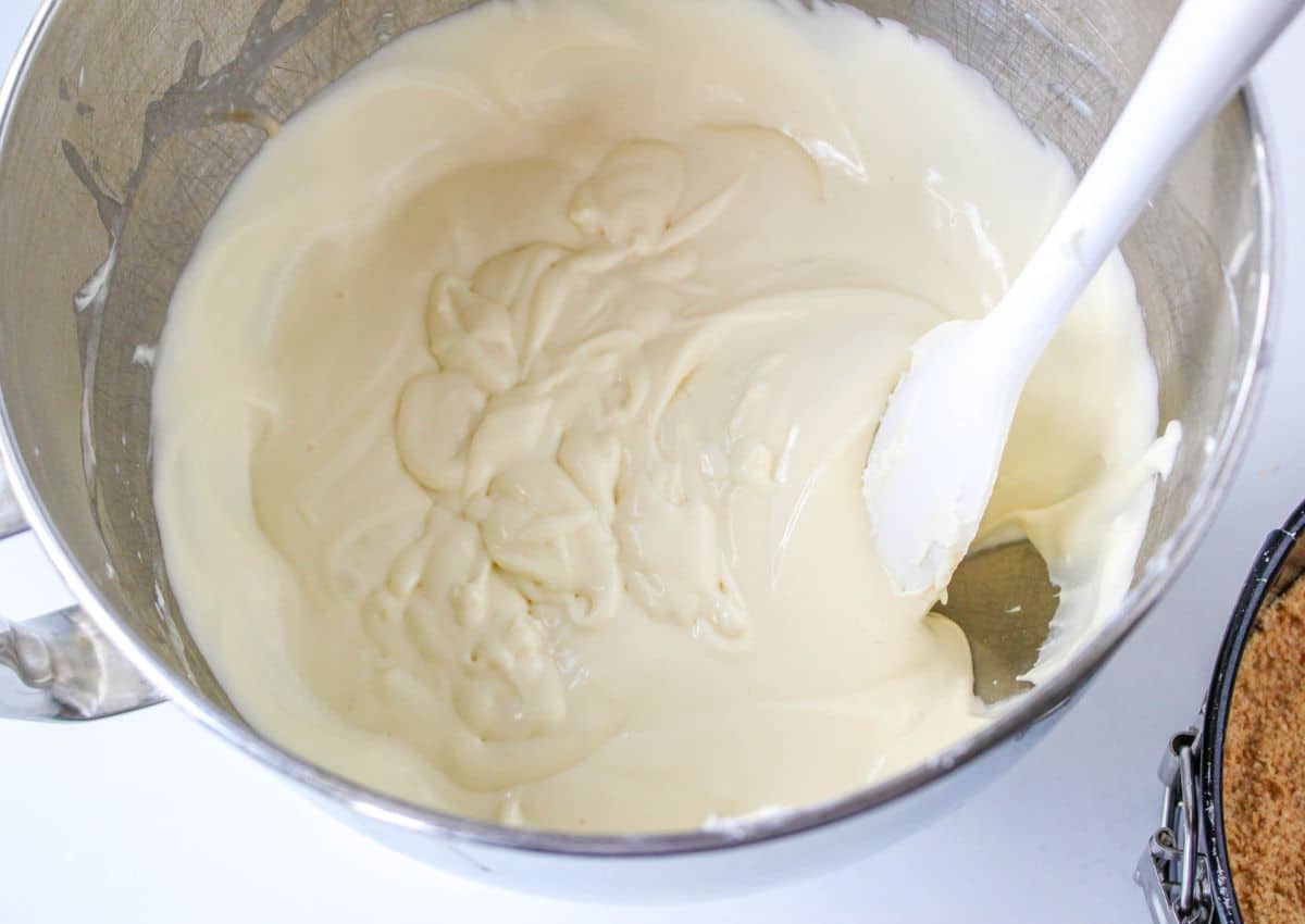 cream cheese and sugar mixed in a stainless steel mixing bowl