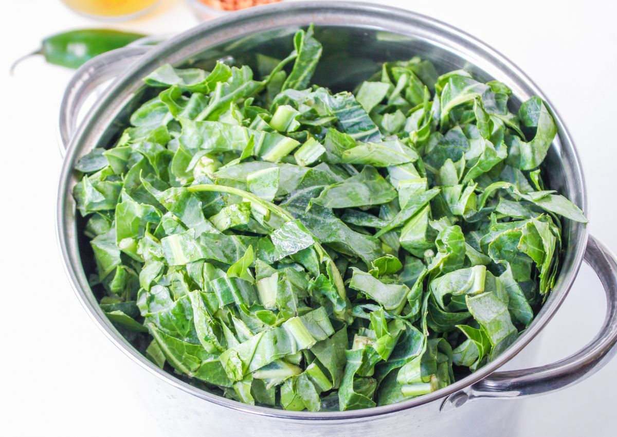 raw collard greens in a stainless steel pot