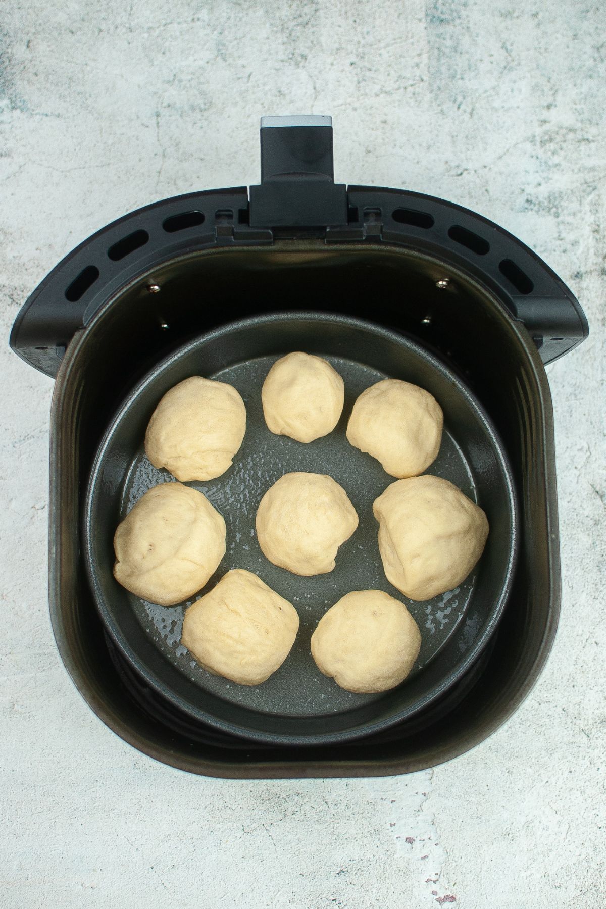 raw dough in a metal pan on the air fryer basket
