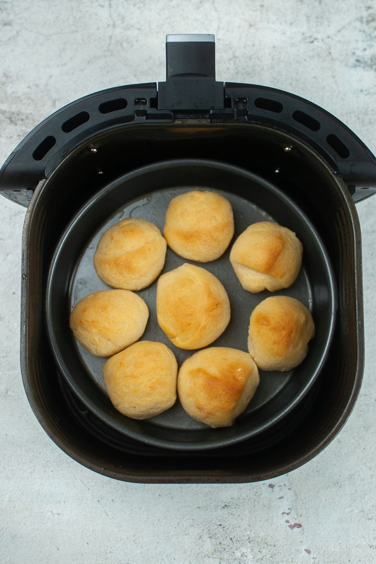 cooked rolls in a pan in an air fryer basket