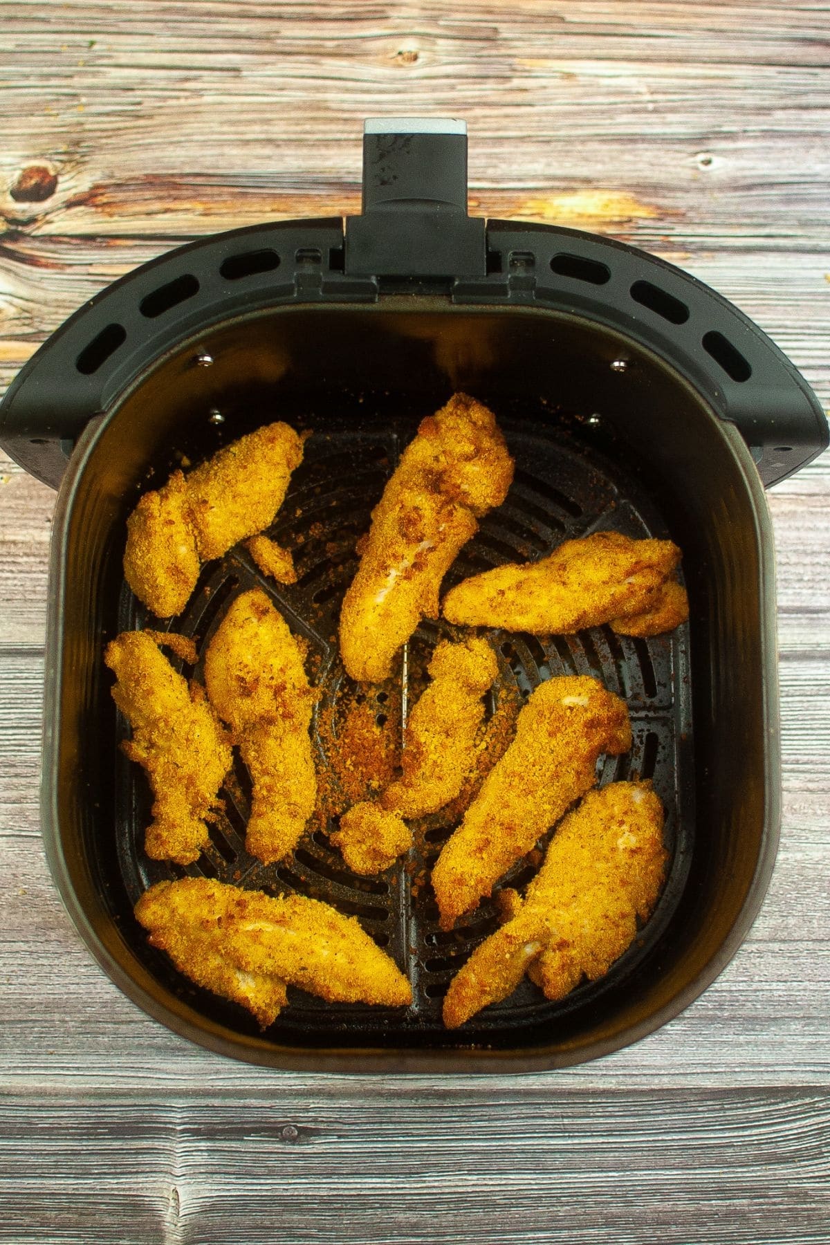 cooked chicken tenders in an air fryer basket