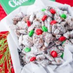 birds eye image of a container filled with chirstmas muddy buddies topped with red and green m&Ms