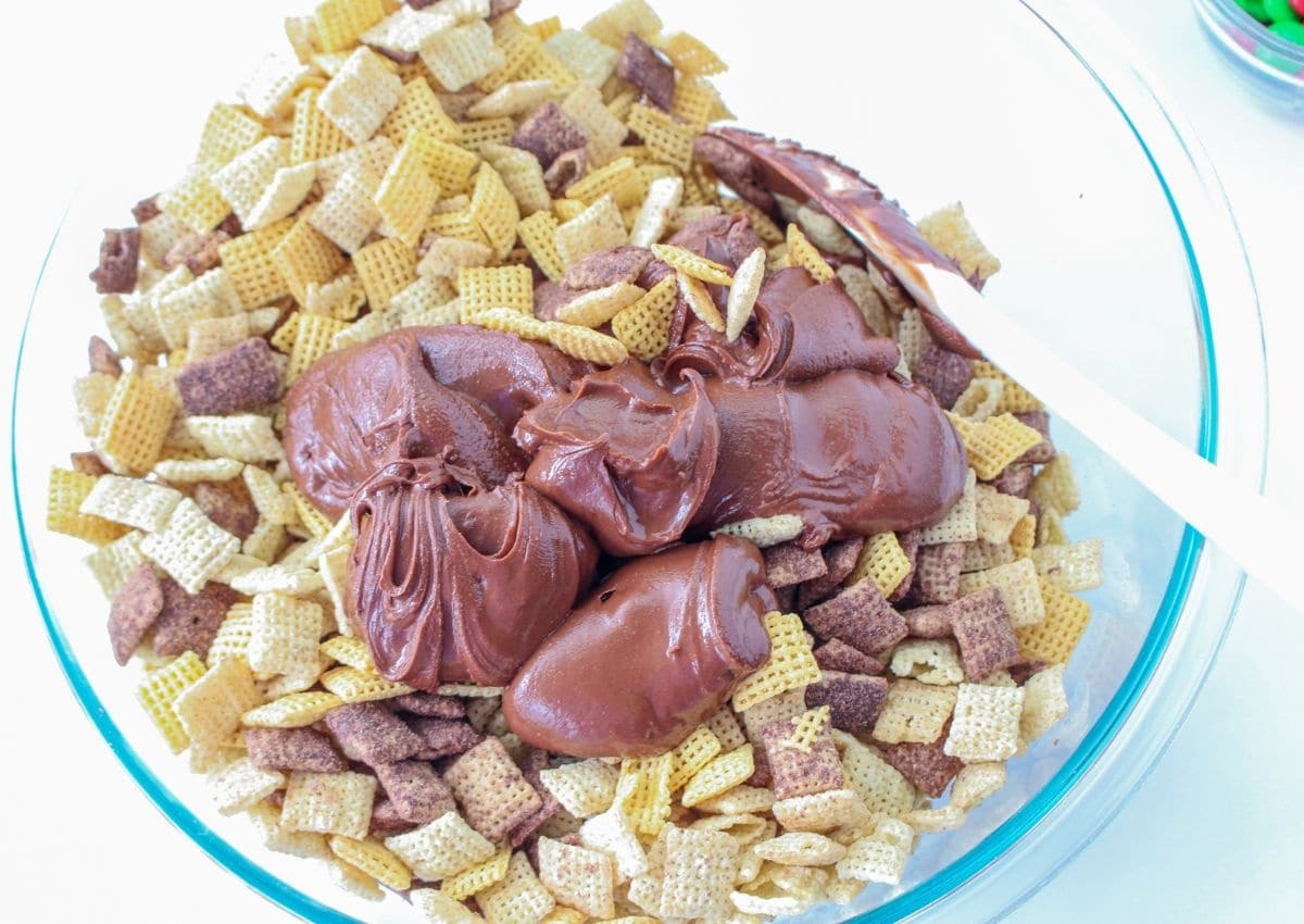melted chocolate and peanut butter being poured over chex cereal