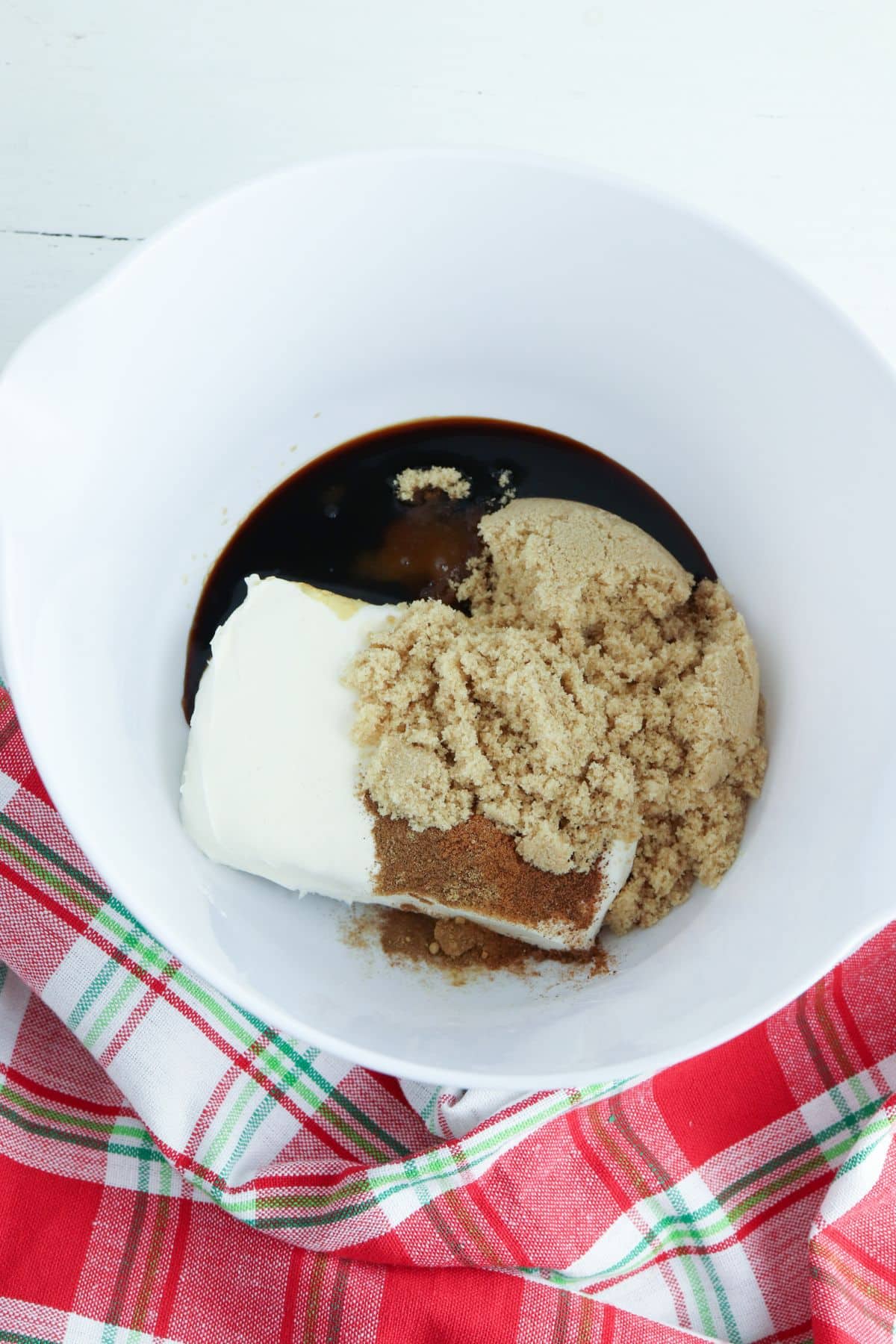 brown sugar, molasses and cream cheese in a white mixing bowl