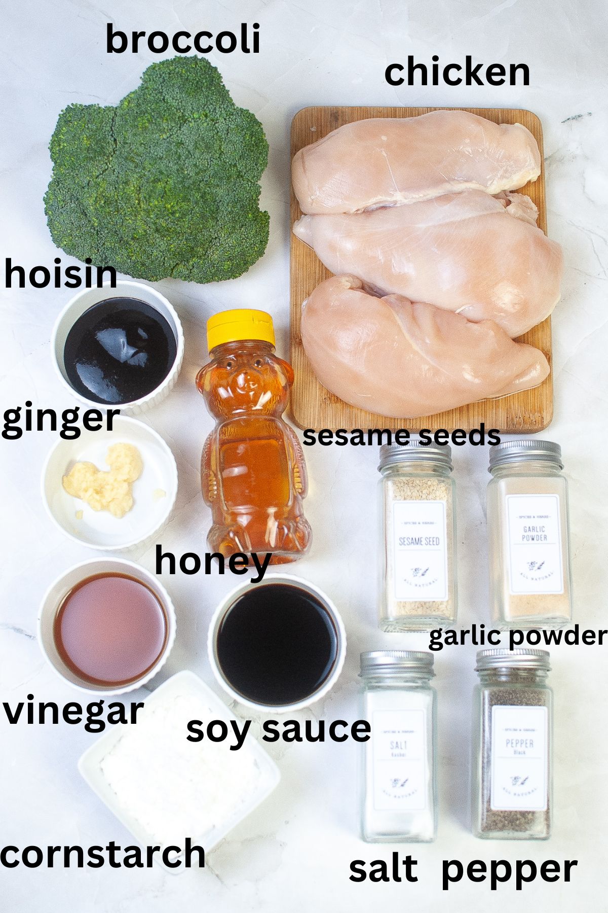 broccoli, chicken breasts, hoisin, ginger, honey, sesame seeds, garlic powder, salt, pepper, vinegar, soy sauce, and cornstarch on a white backdrop