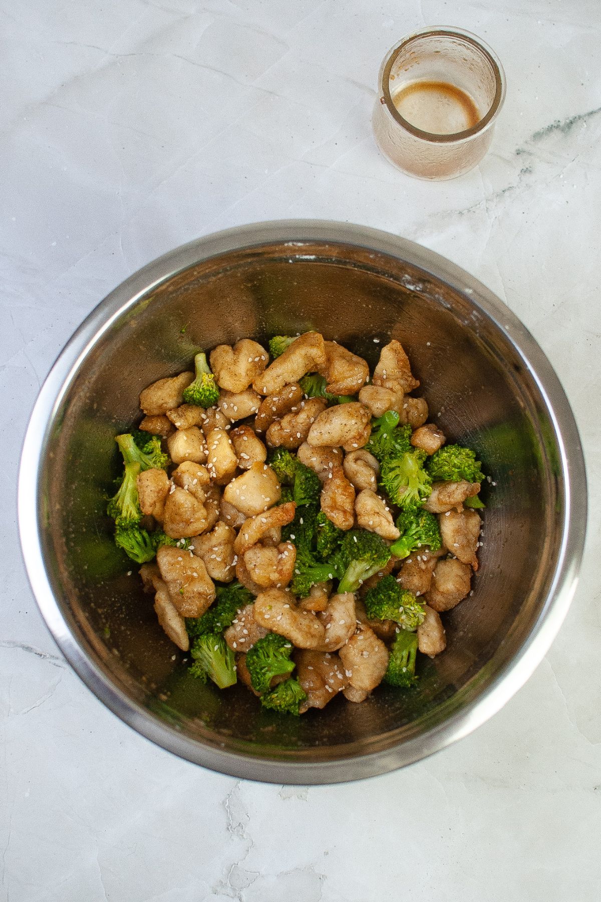 cooked chicken and broccoli being coated in sauce