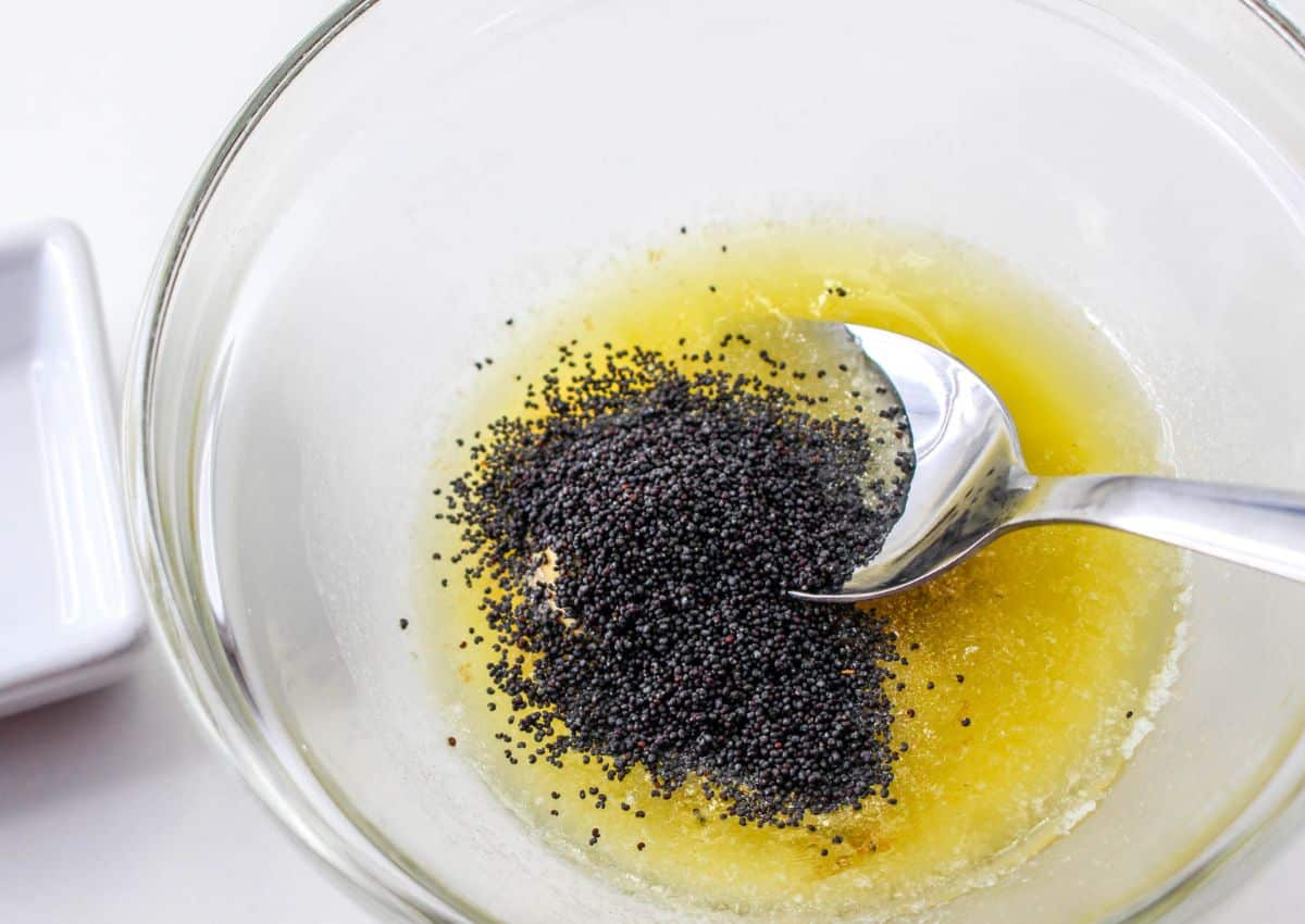 poppy seeds being mixed into melted butter