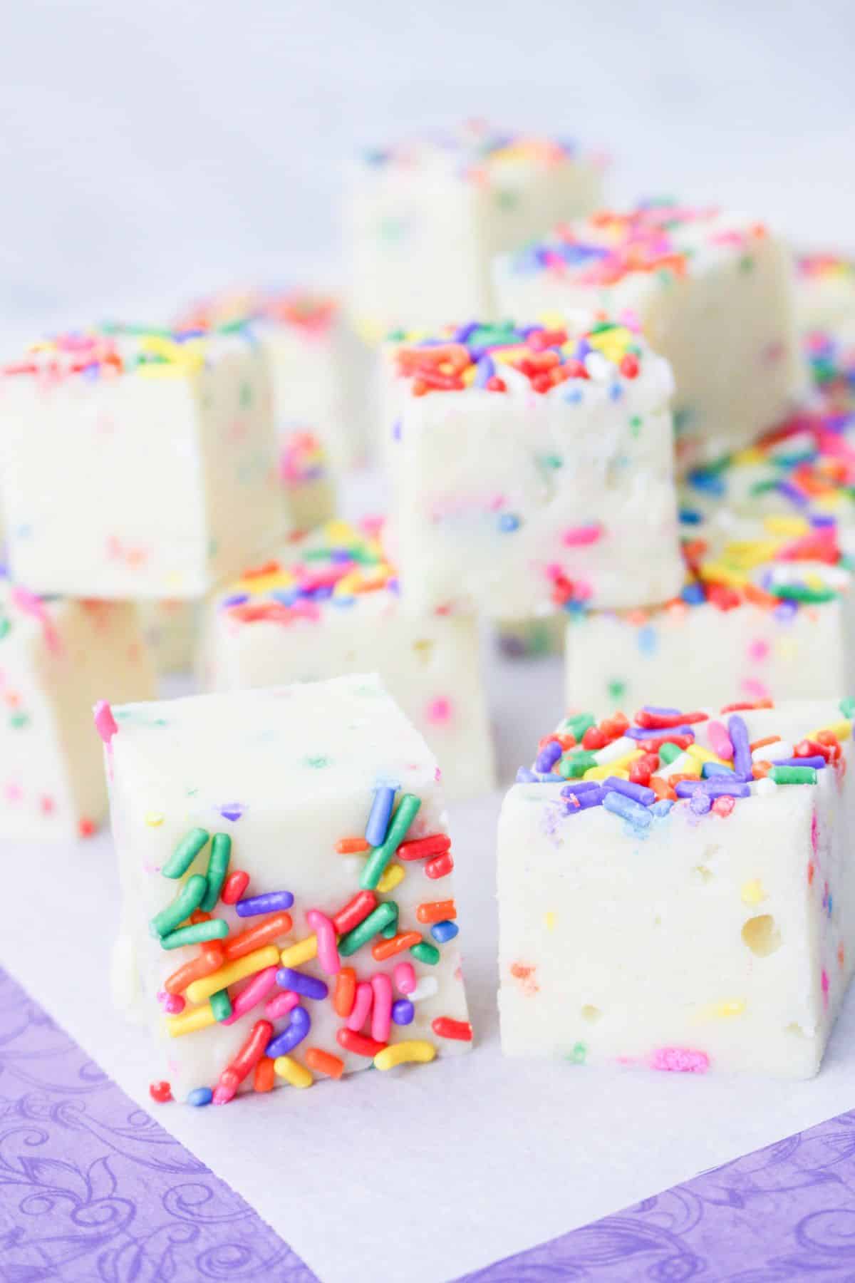 squares of funfetti fudge on a white and purple background
