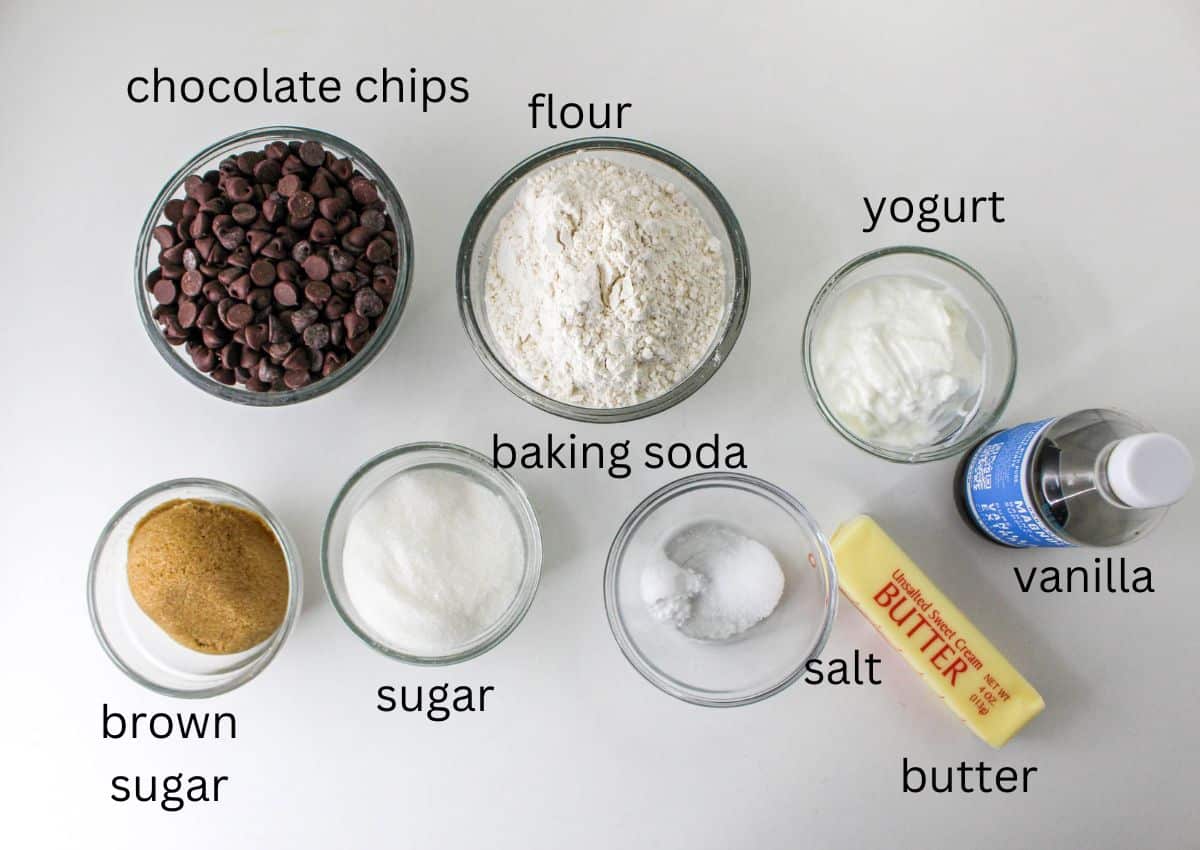 chocolate chips, flour, yogurt, vanilla, butter, baking soda, sugar, brown sugar on a white background