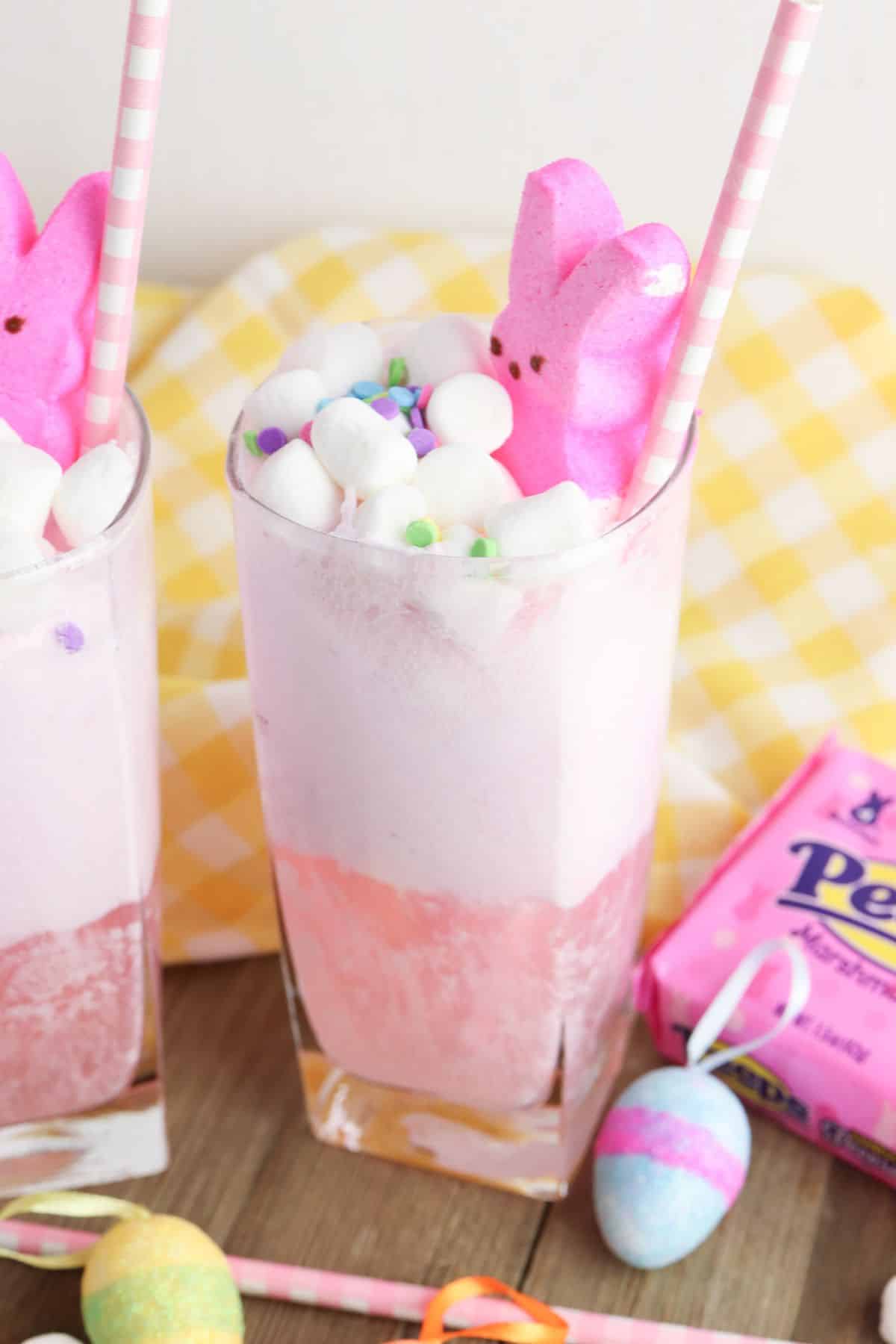 glass of pink punch topped with marshmallows and pink peep