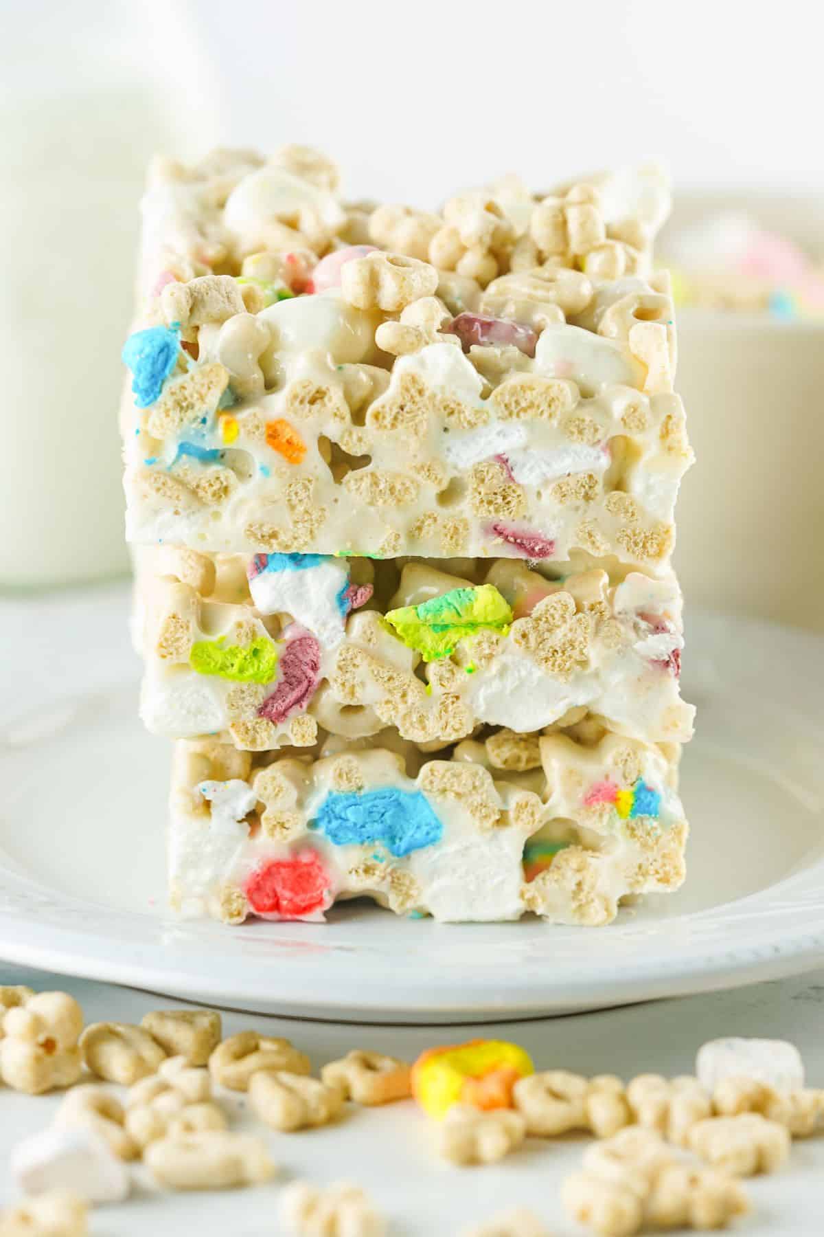 three lucky charms treats stacked on top of one another on a white plate
