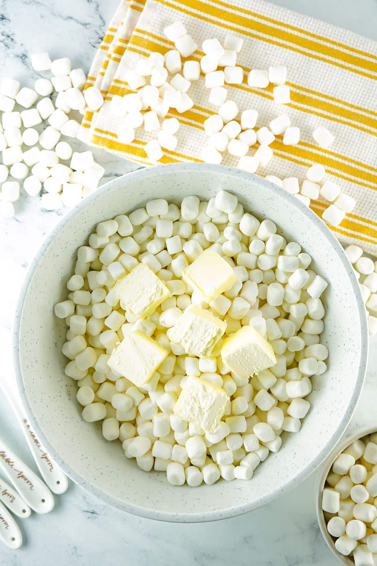 butter and marshmallows on a white large mixing bowl