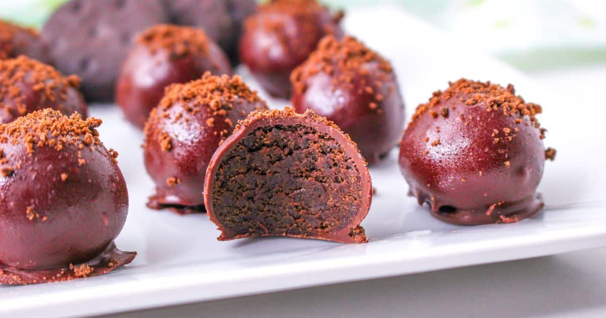 thin mint truffles on a white plate with one in the front row bitten in half.