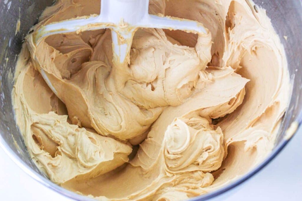 peanut butter frosting in the bowl of a stand mixer