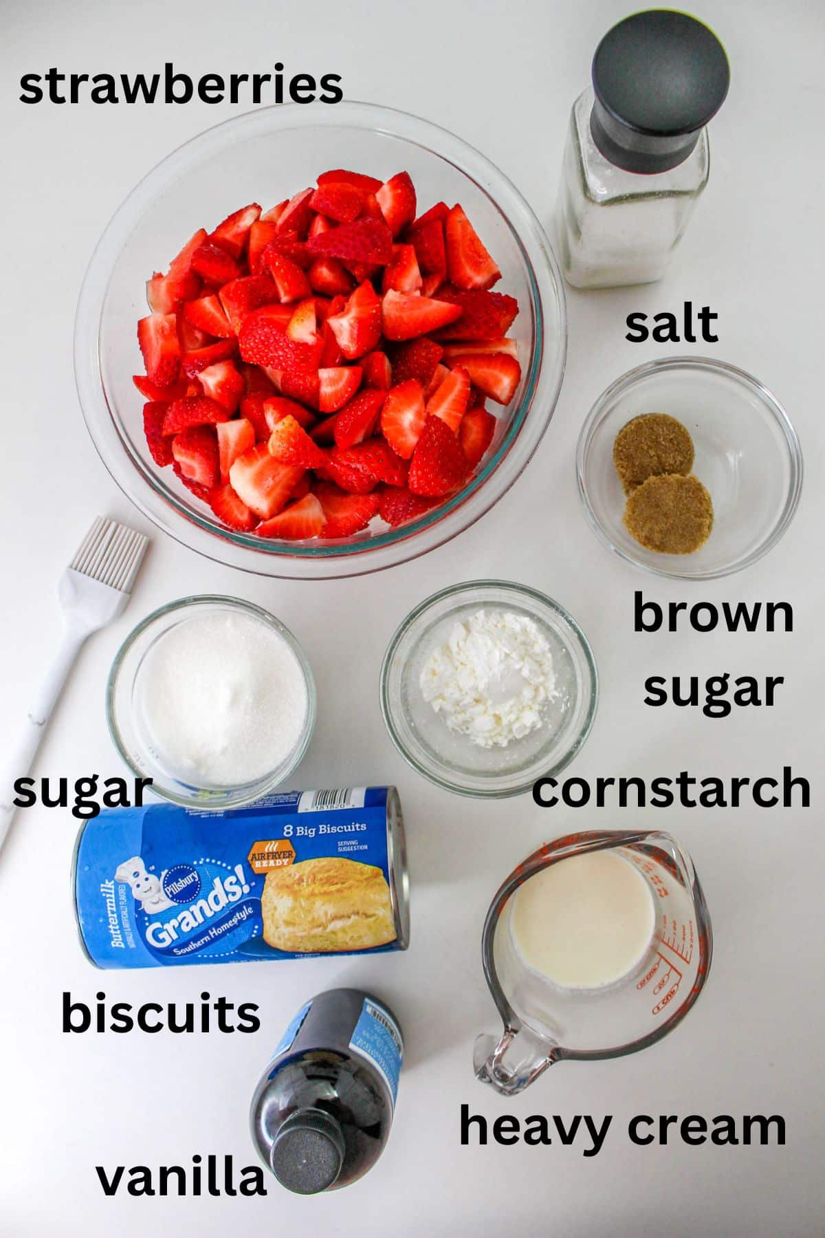strawberries, salt, brown sugar, sugar, biscuits, vanilla, heavy cream and cornstarch on a white backdrop