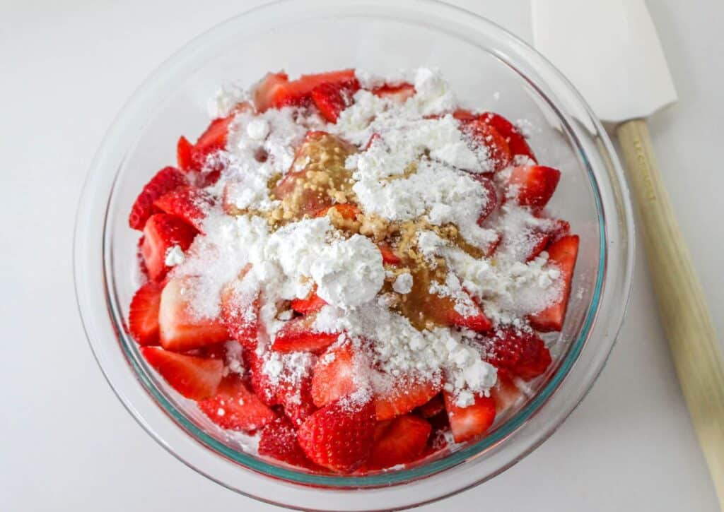 strawberries, sugar and vanilla in a glass mixing bowl