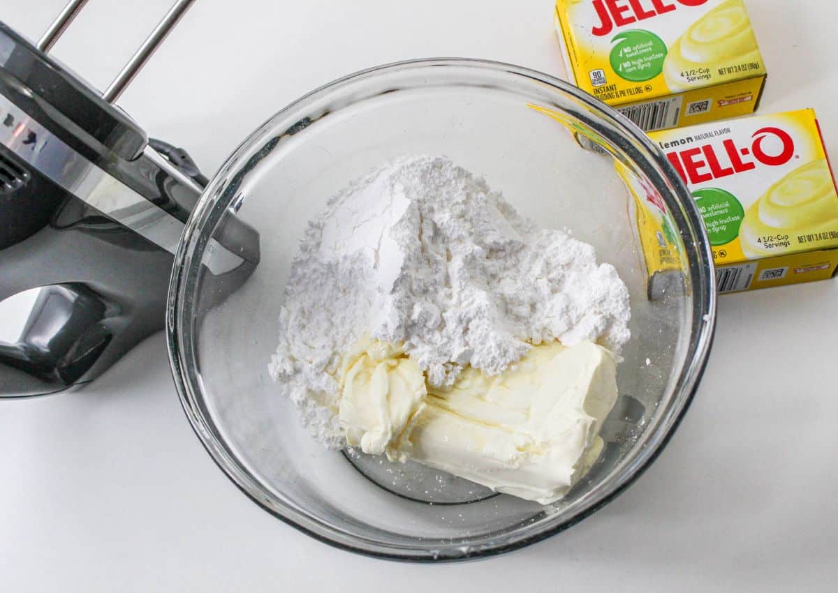 cream cheese and powdered sugar in a glass mixing bowl