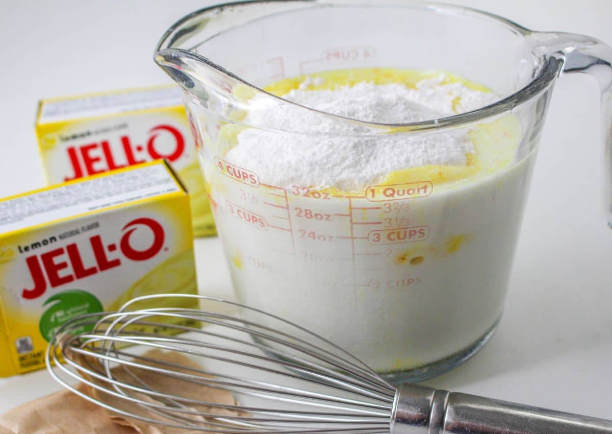 lemon pudding being mixed with in a glass mixing cup