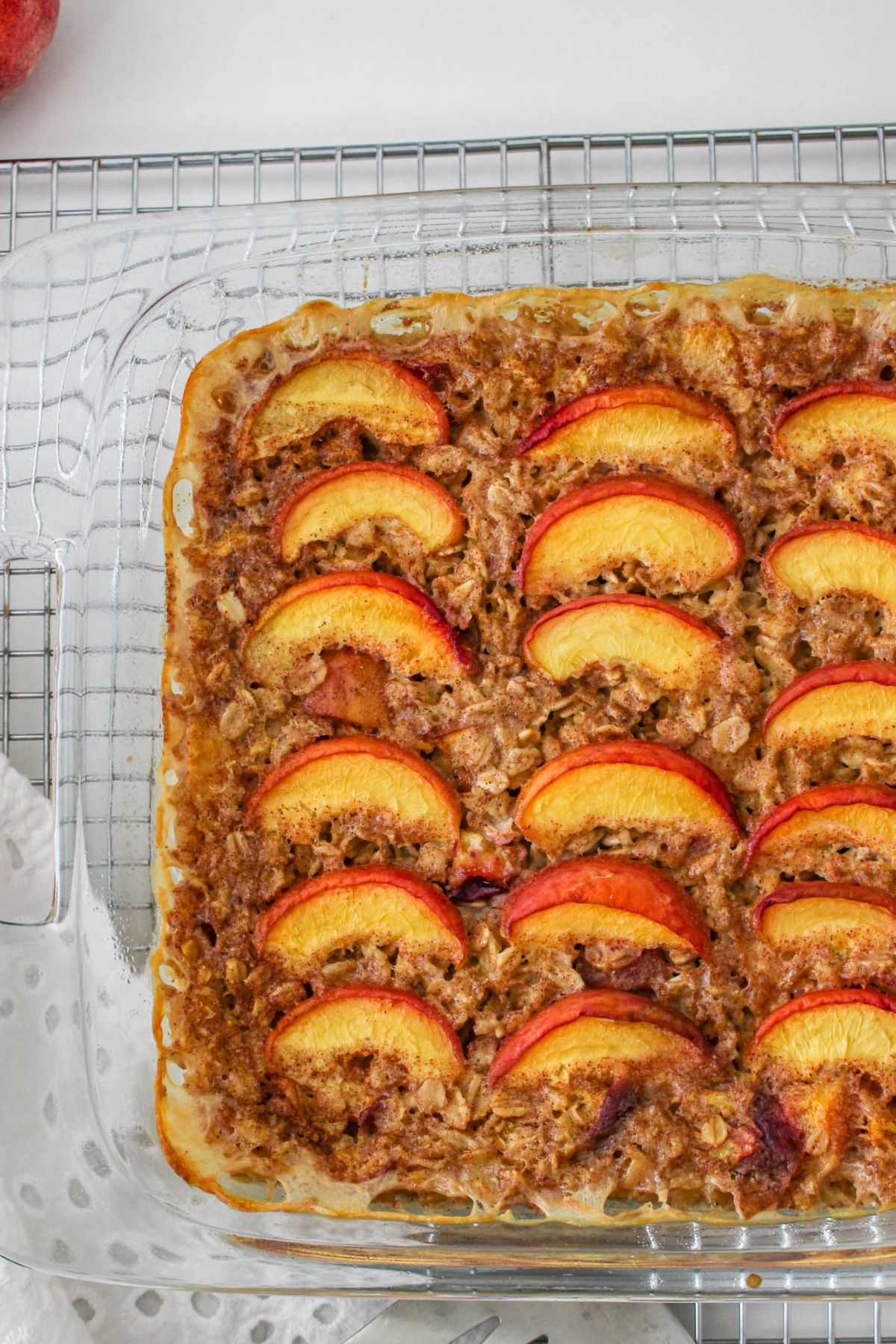 off center image of a glass casserole dish filled with peach baked oatmeal