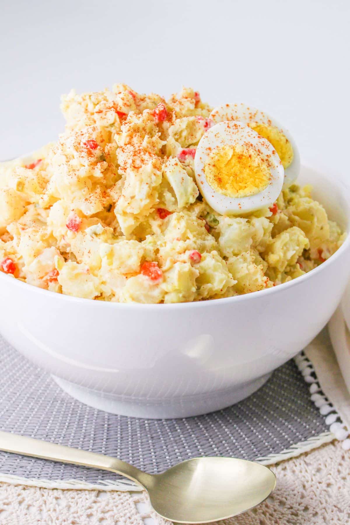 white bowl filled with pimento potato salad topped with hard boiled eggs