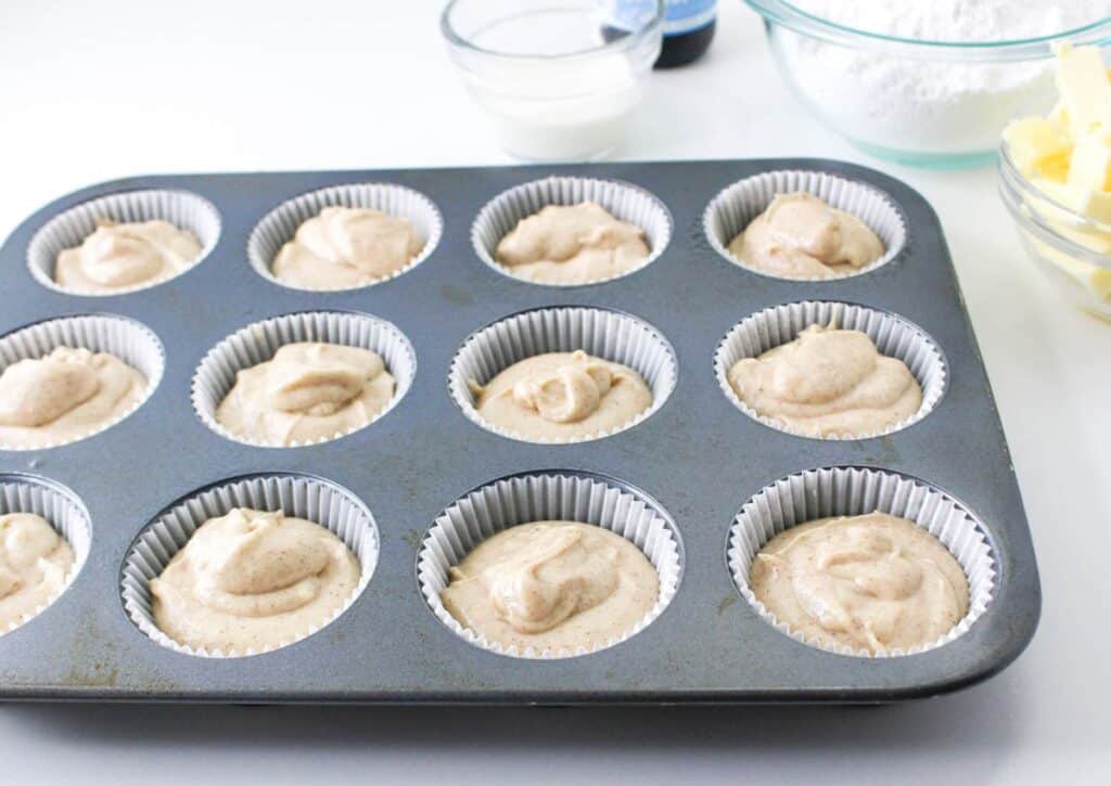 cupcake batter in paper liners in a muffin tin