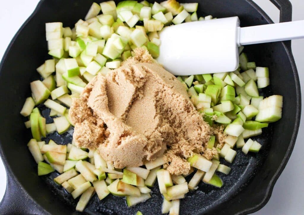 brown sugar and diced apples in a cast iron skillet