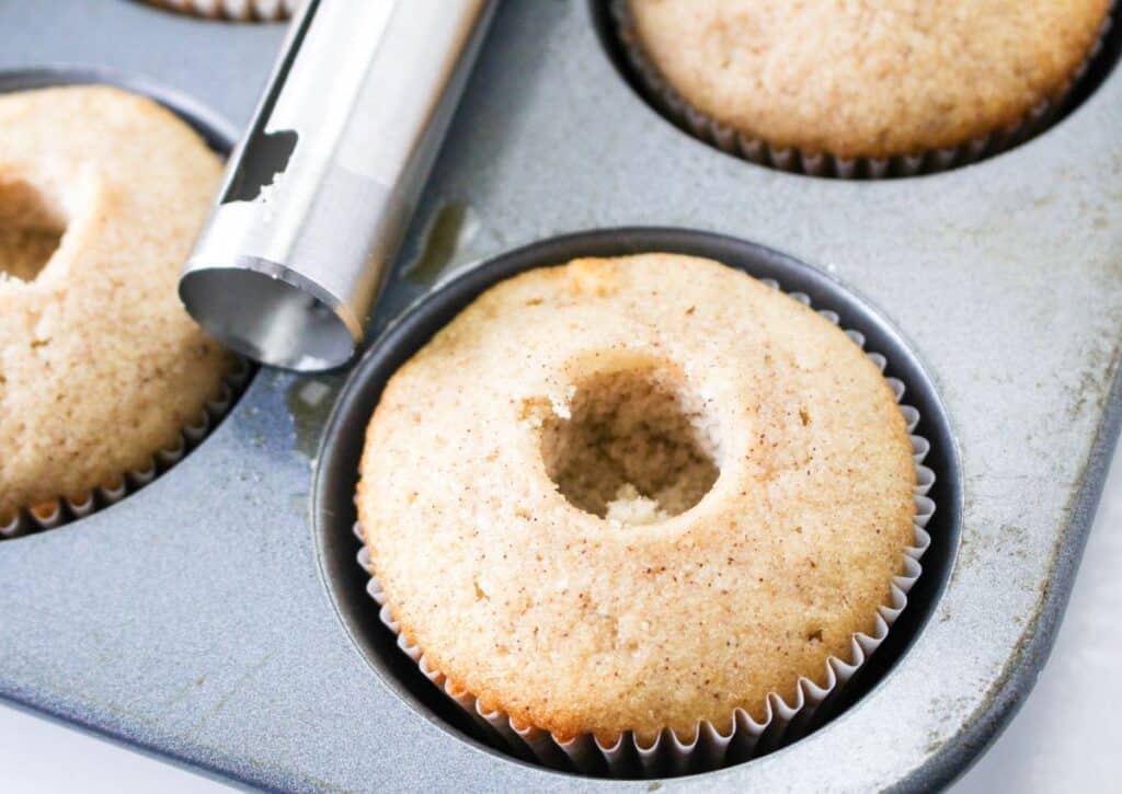 the center being removed from the center of a cupcake in a cupcake pan